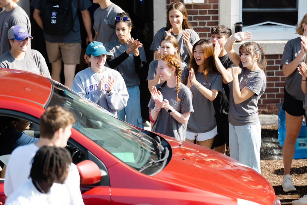 People cheer as a car pulls up