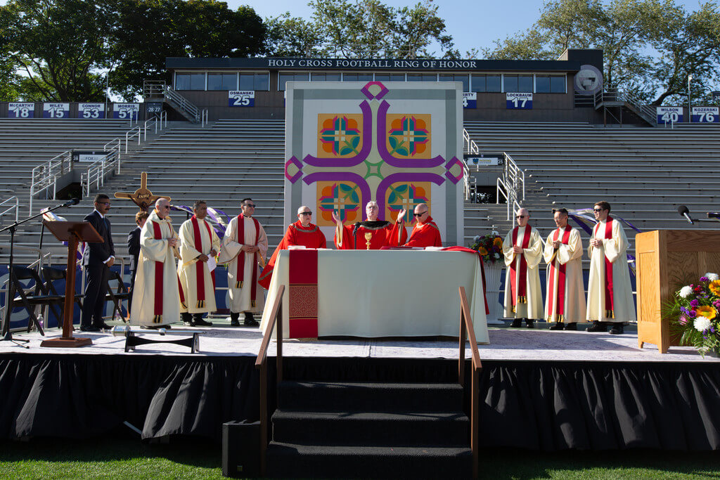 Group of Catholic priests celebrate Mass around an altar