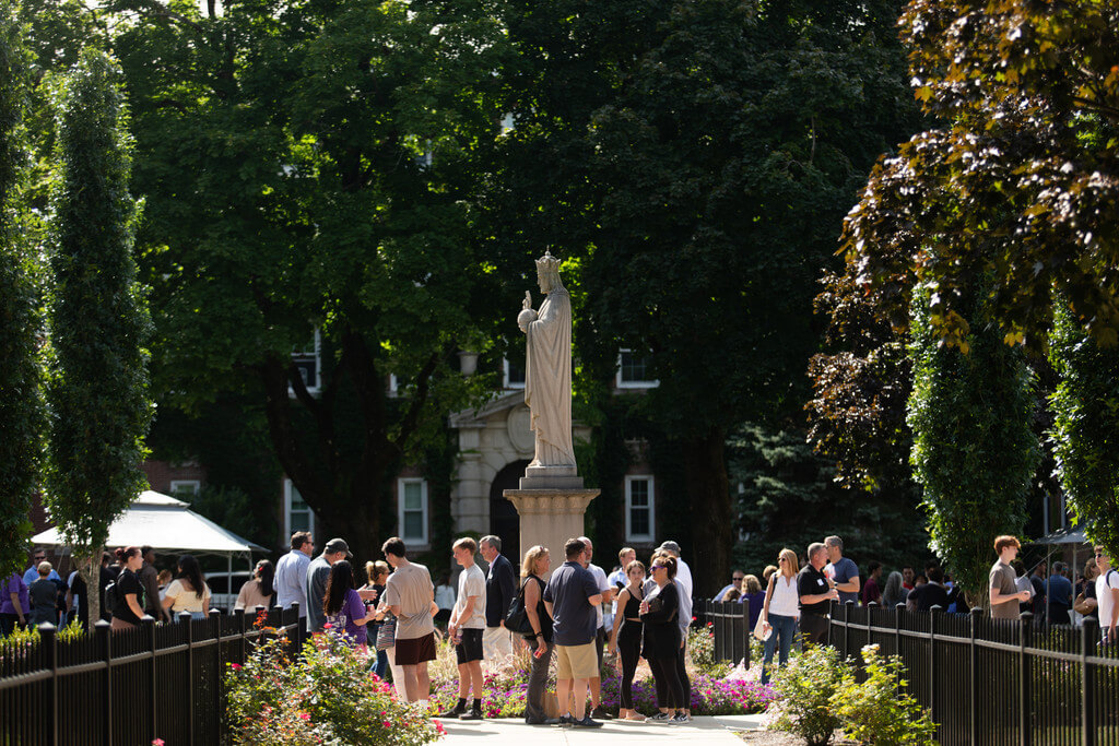 group of people stand under statue talking