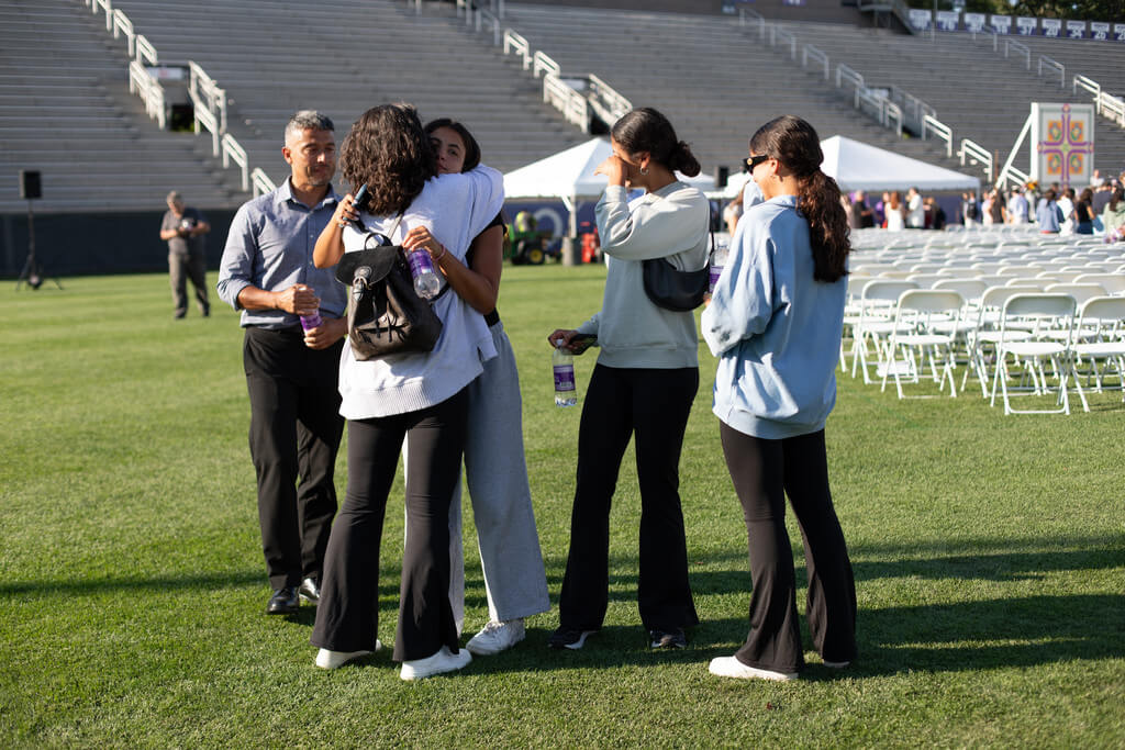 Two people embrace on a football field