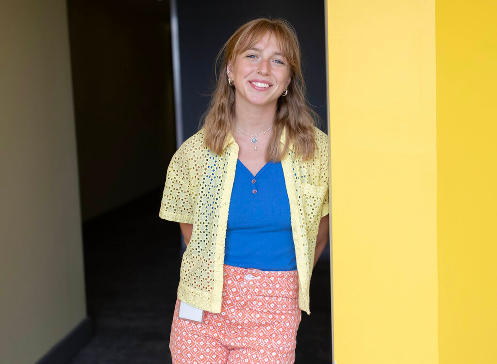 Smiling woman leans against wall