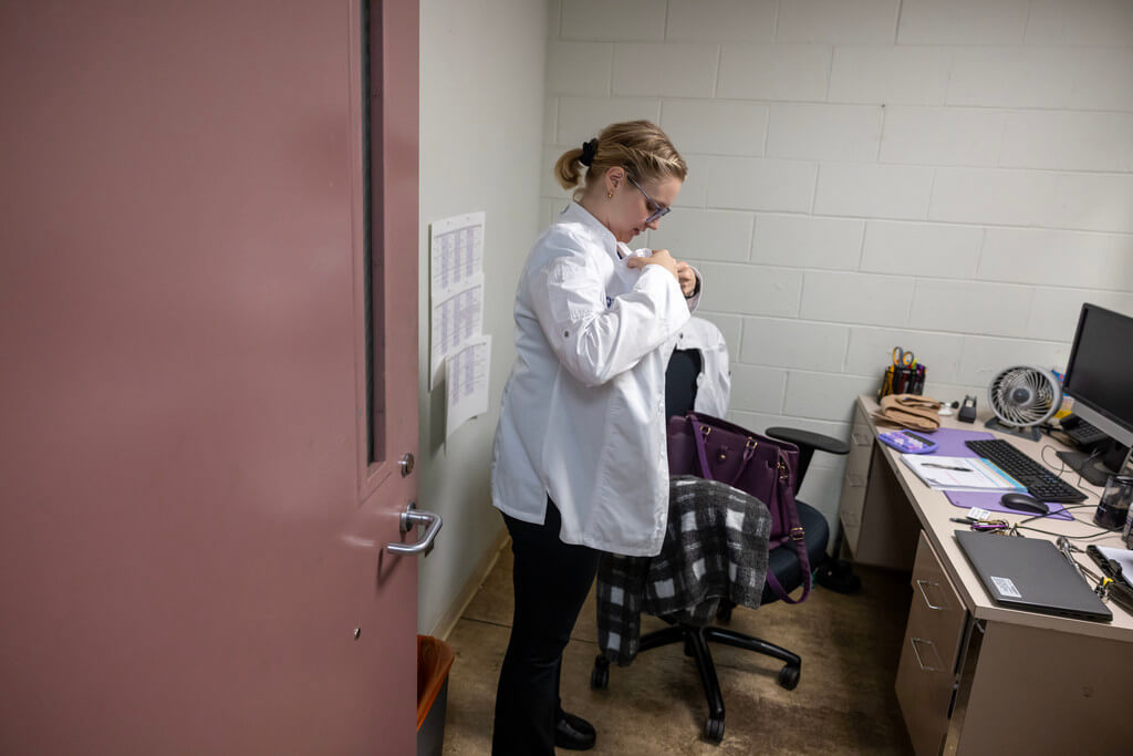 L’Ecoyer puts on her chef’s coat in her Lower Kimball office before heading to the kitchen to start donut production.