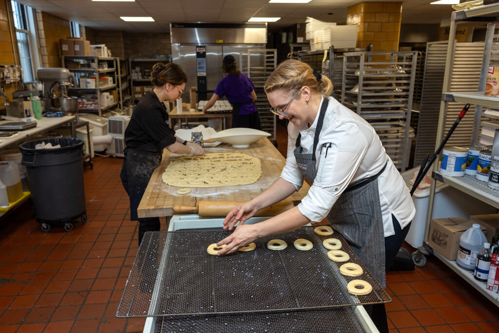 L’Ecoyer and Lucier work together to roll and press two batches of dough with the goal of making approximately 300-400 donuts total.