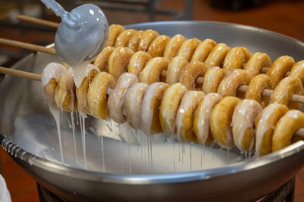 Glaze being poured over donuts