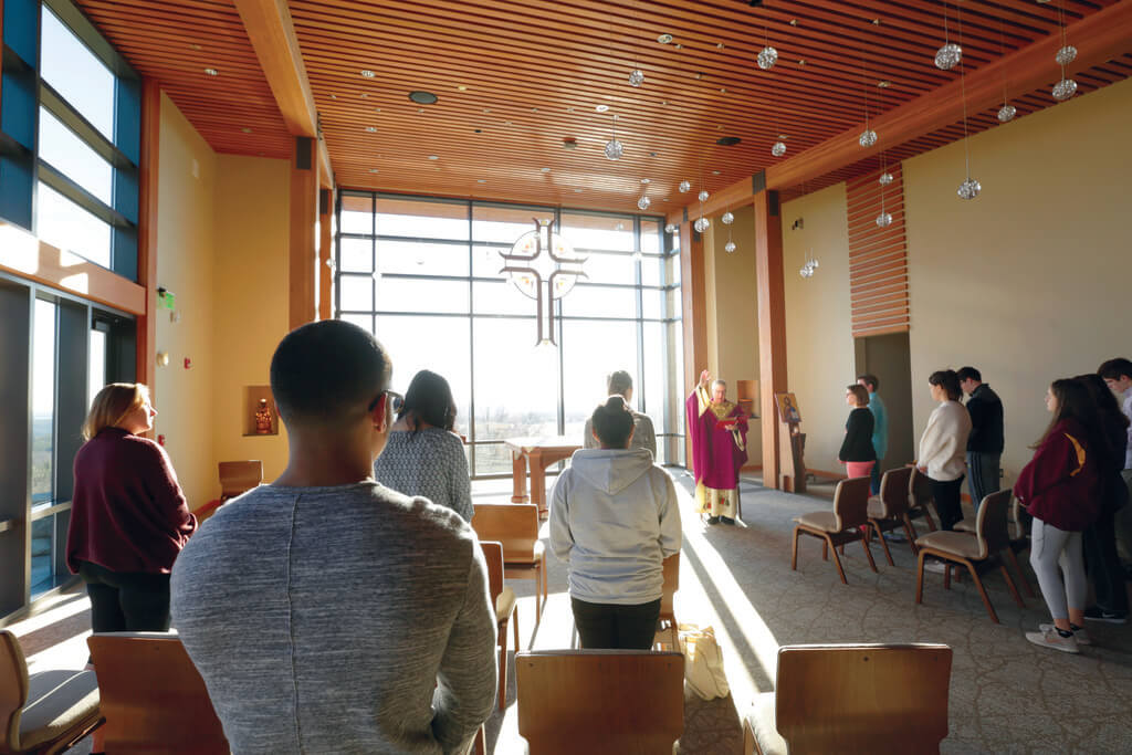 Priests speaks to people in a chapel