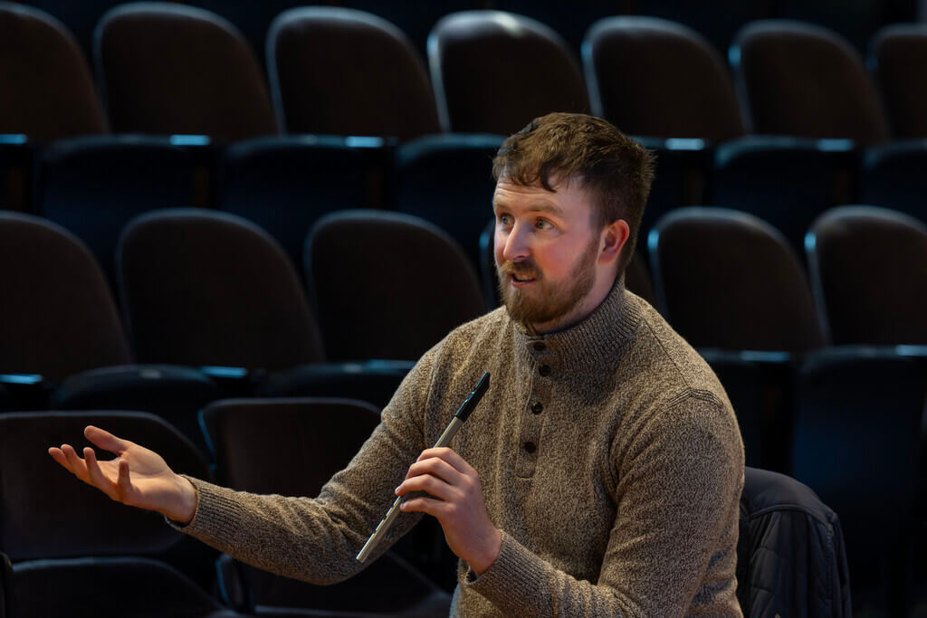 male musician holding tin whistle
