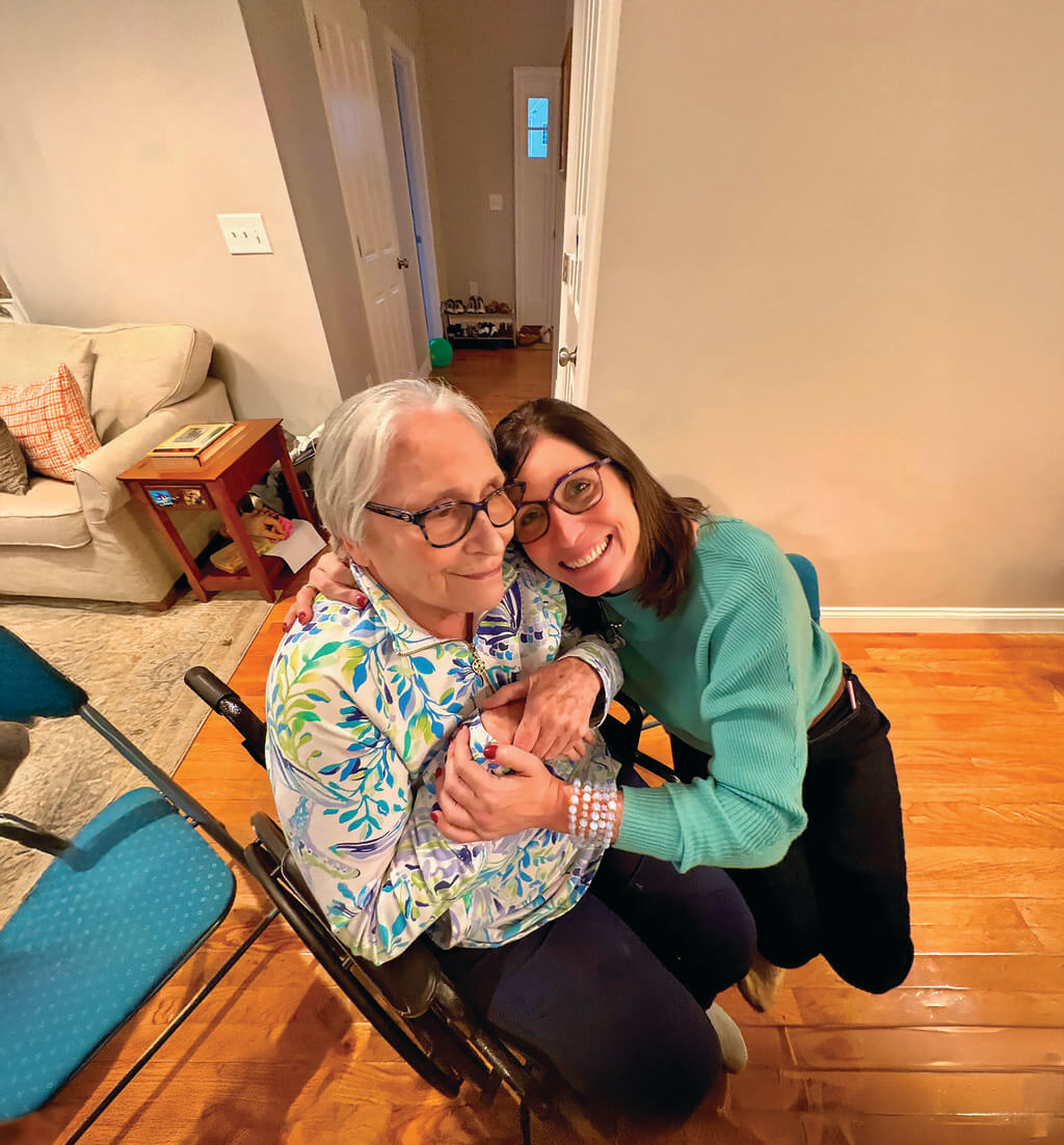 Crouching woman hugs woman in chair