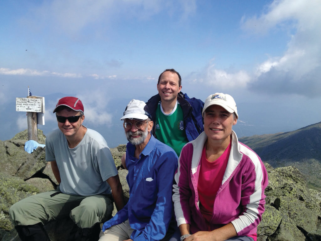 Four people sit on mountaintop