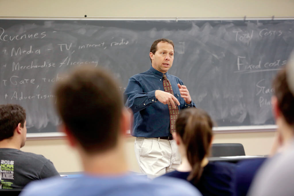 Man teaches at front of classroom