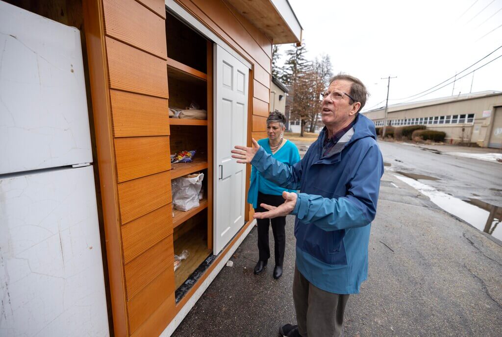 Man and woman look at outdoor refrigerator