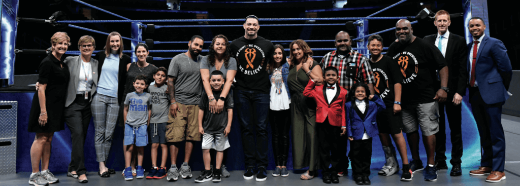 group of people stand outside a wrestling ring