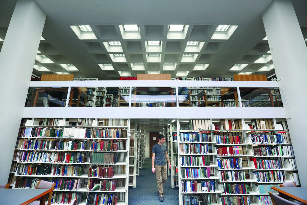 Student walking through the stacks