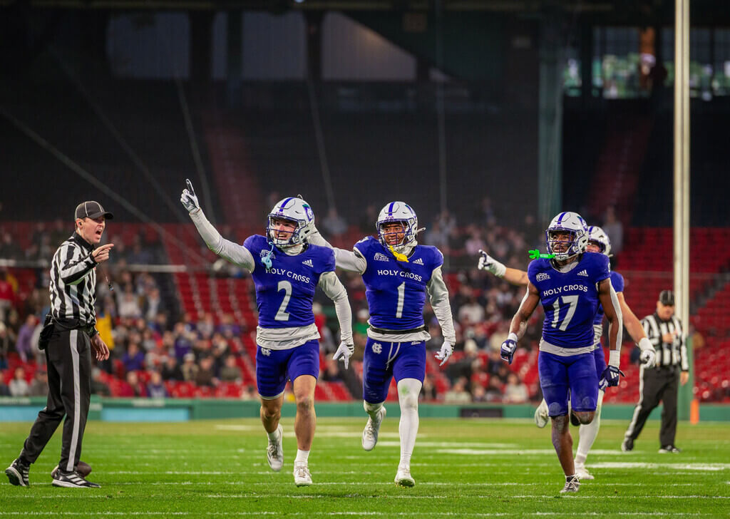 Holy Cross football players holding up #1