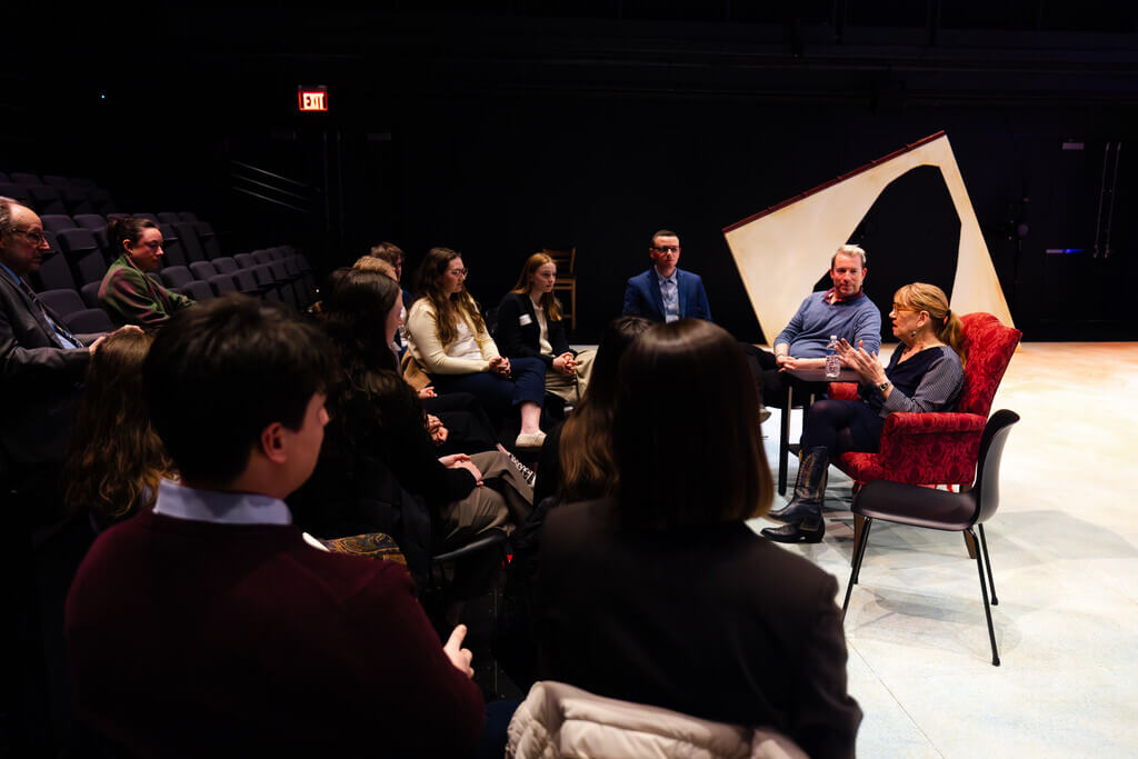 Woman in chair speaks with small crowd