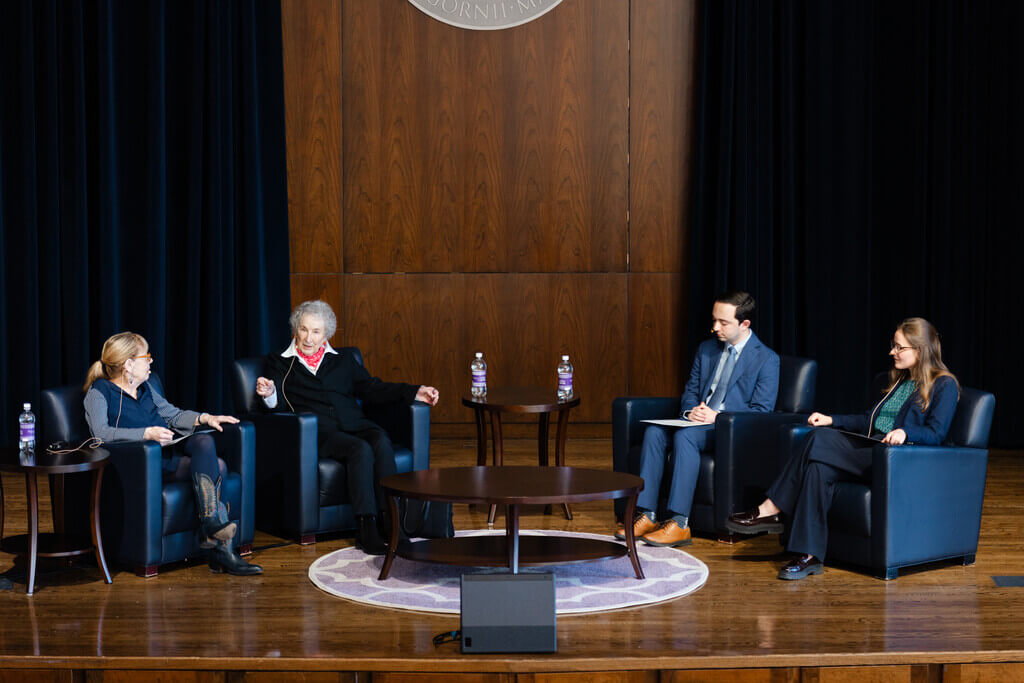 Four people in chairs sit in conversation