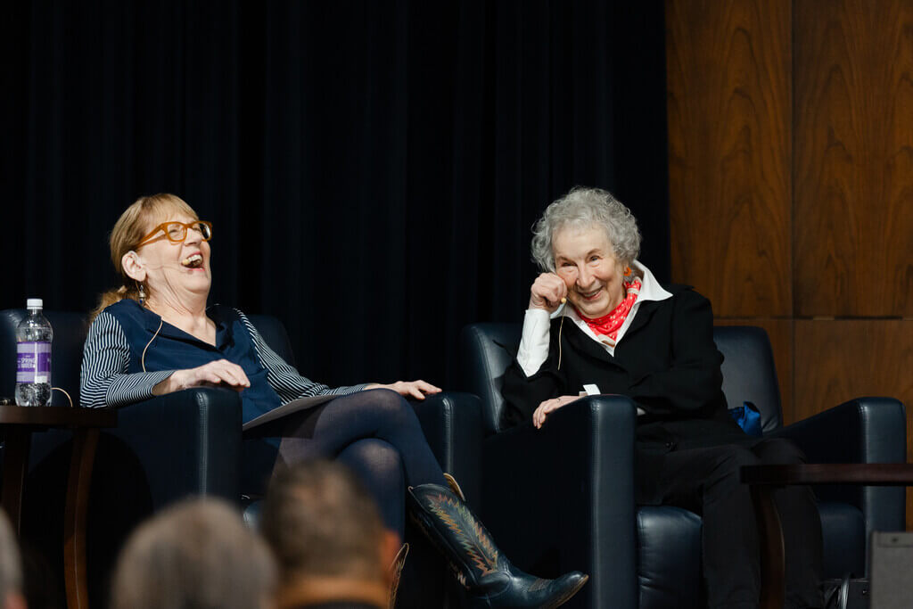 Two seated women laugh together