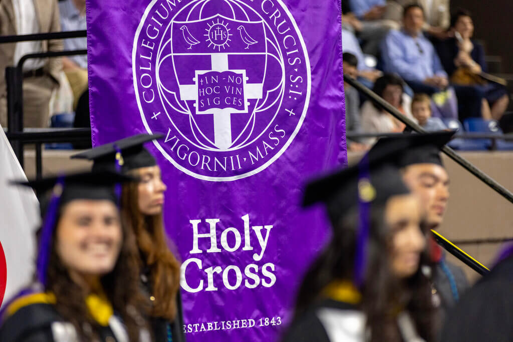 Holy Cross flag surrounded by graduates