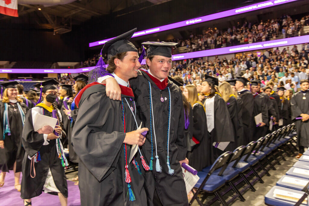 Two graduates with their arms around each other