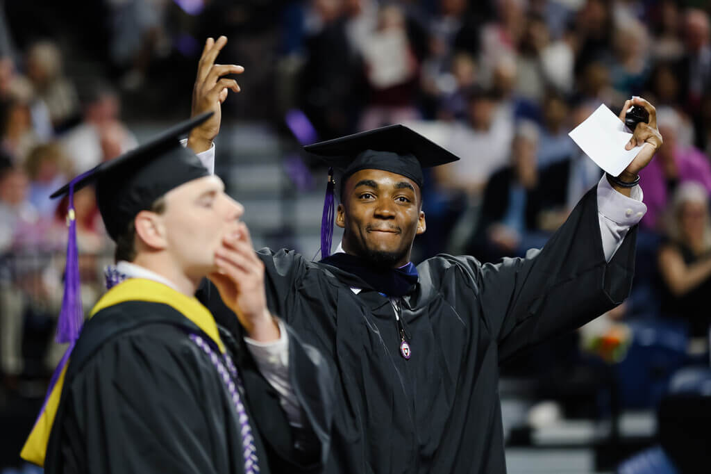 Graduate with his arms raised
