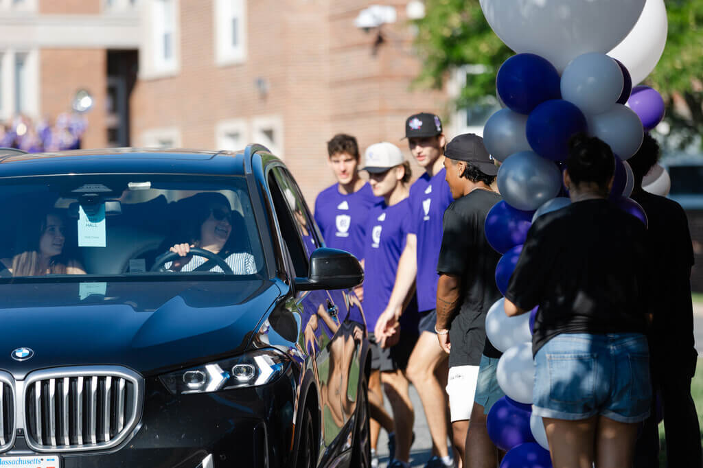 Students greet people in a car