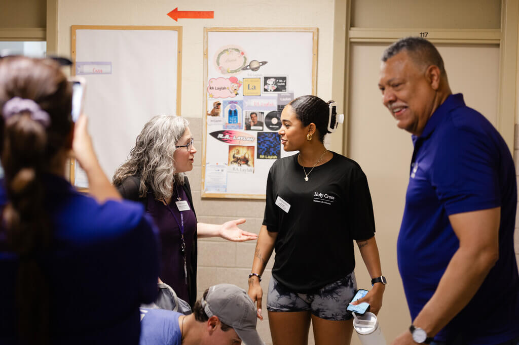 Three people in a dorm hallway