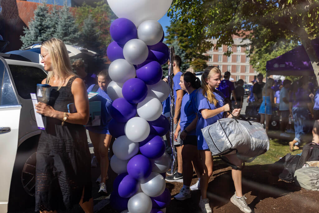 Students unloading belongings from a car