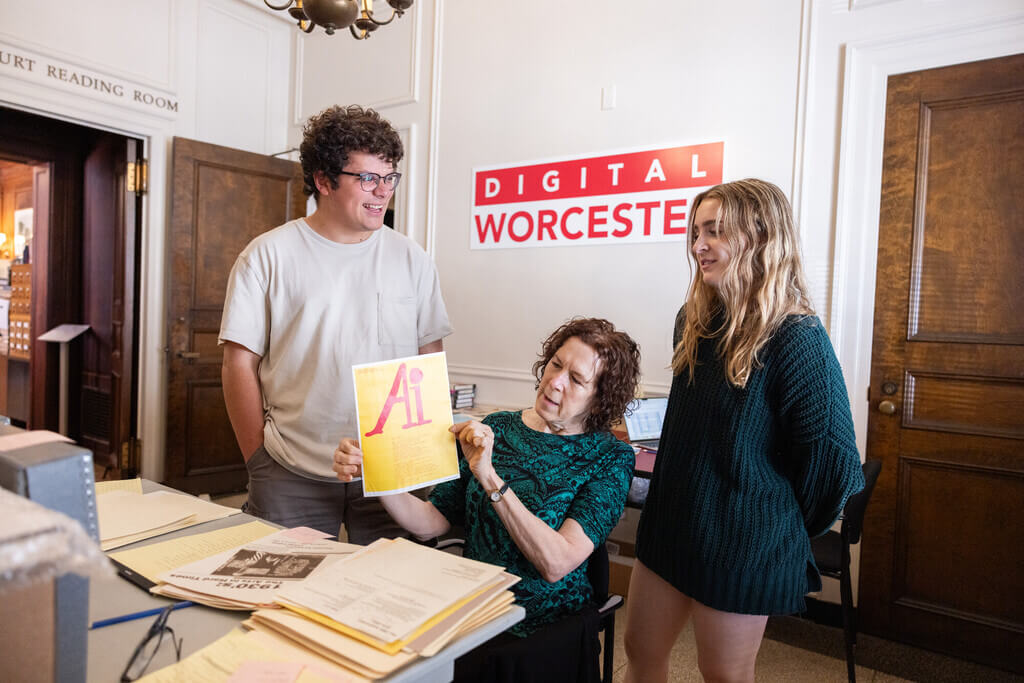 Two students and a professor looking at archival materials