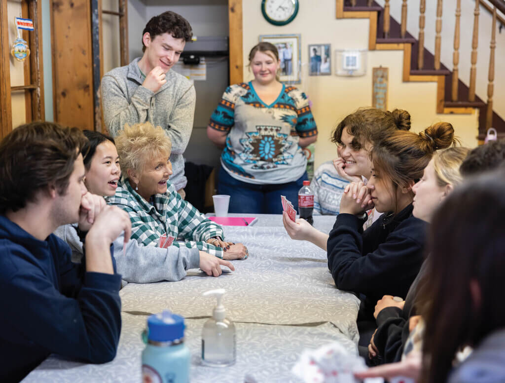 Group of people playing cards around a table