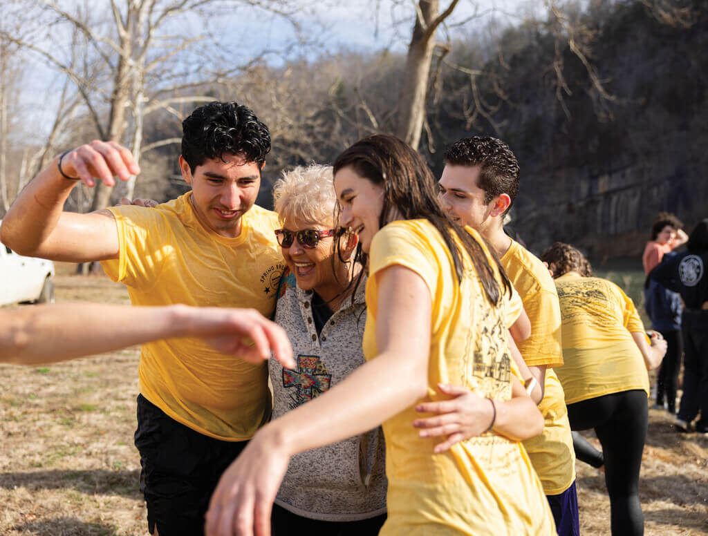 Two students hugging a woman