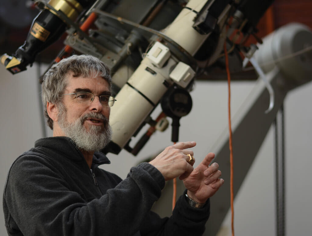 Brother Guy Consolmagno in front of a telescope