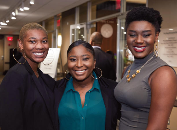 Three woman pose smiling