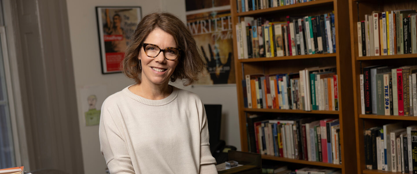 woman with glass in office holding a book