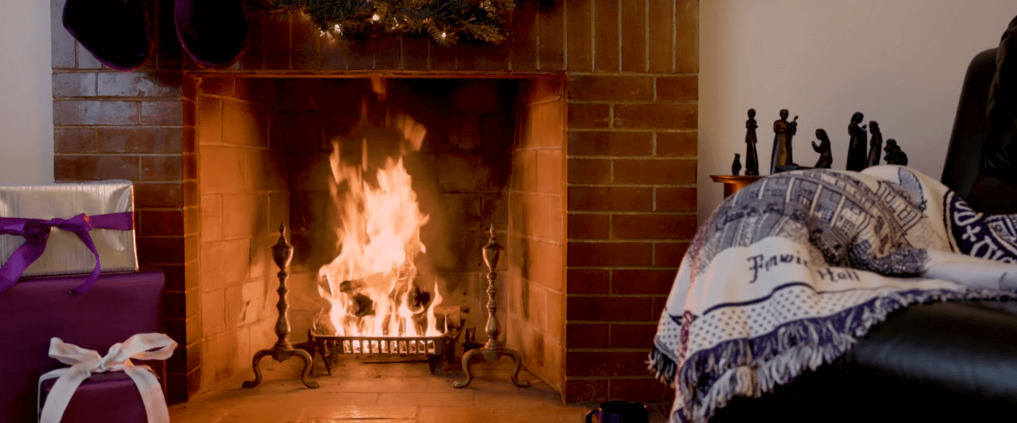 Fire in a fireplace decorated for a Holy Cross-themed Christmas
