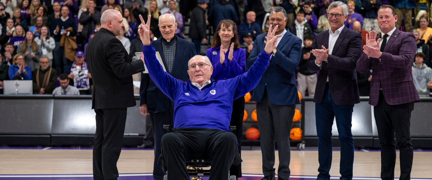 man in wheelchair waves at crowd