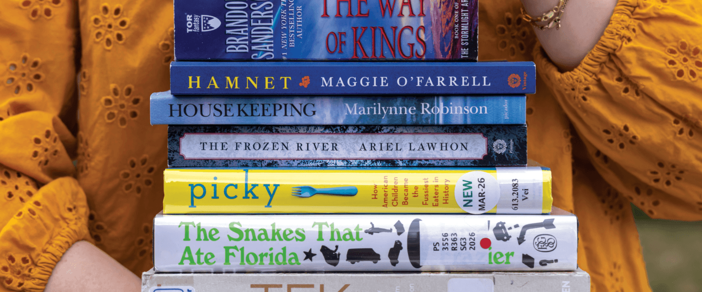 Hands holding a stack of books