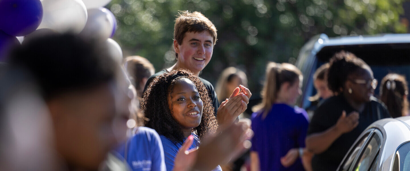 Students clapping as cars drive up