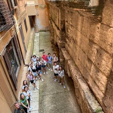 People stand in a Roman aqueduct.