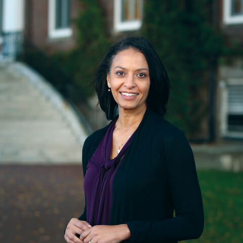 Woman stands in front of brick building