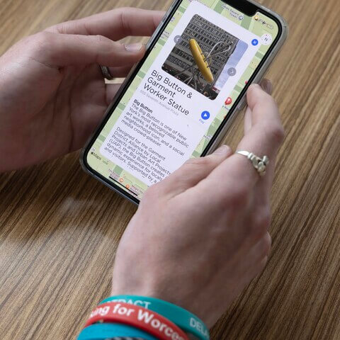 Two hands holding a phone with the Garment District app on the screen