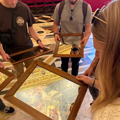 Students looking at art through a mirror