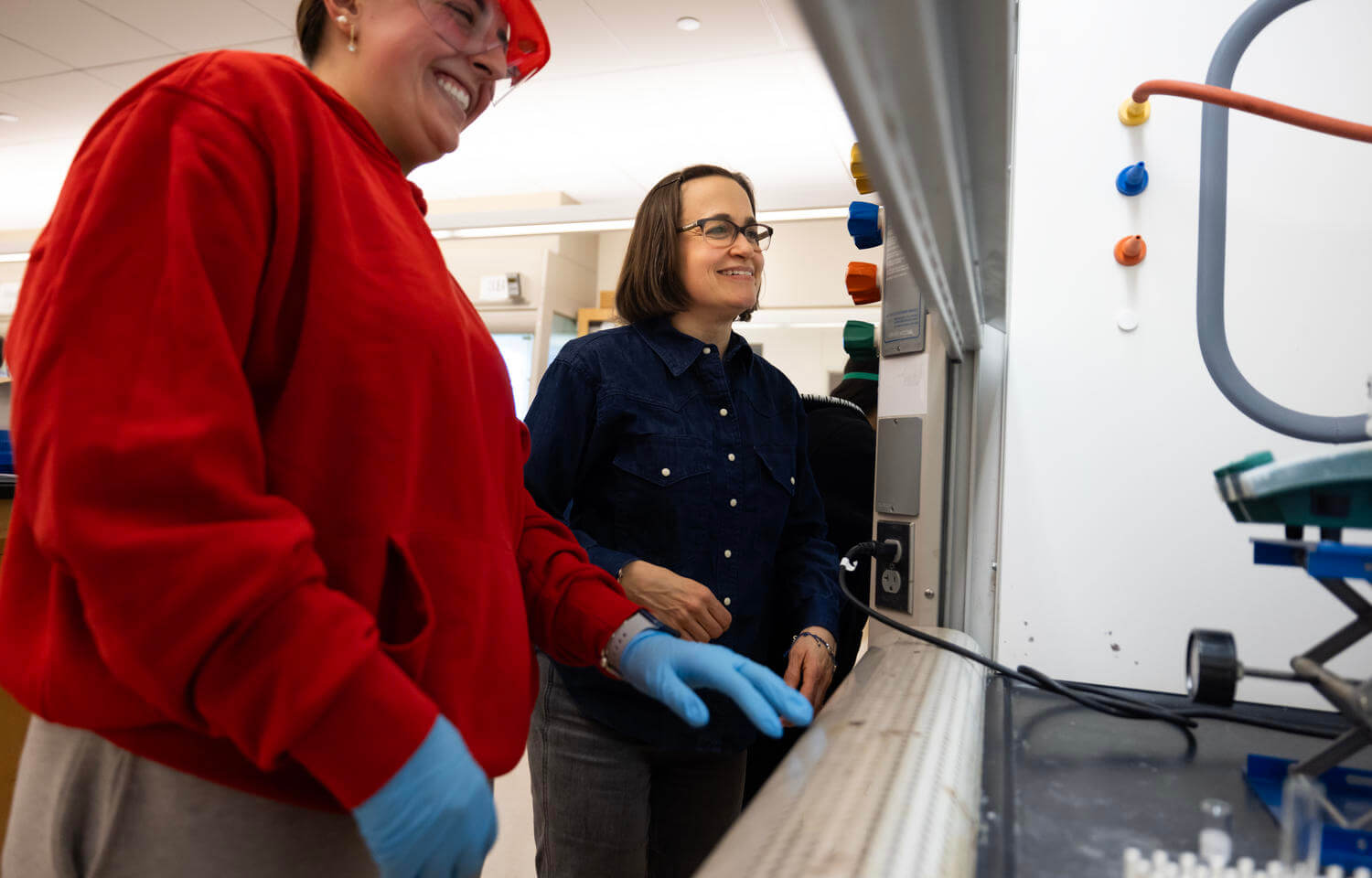 Chemistry student works alongside her professor in a lab.