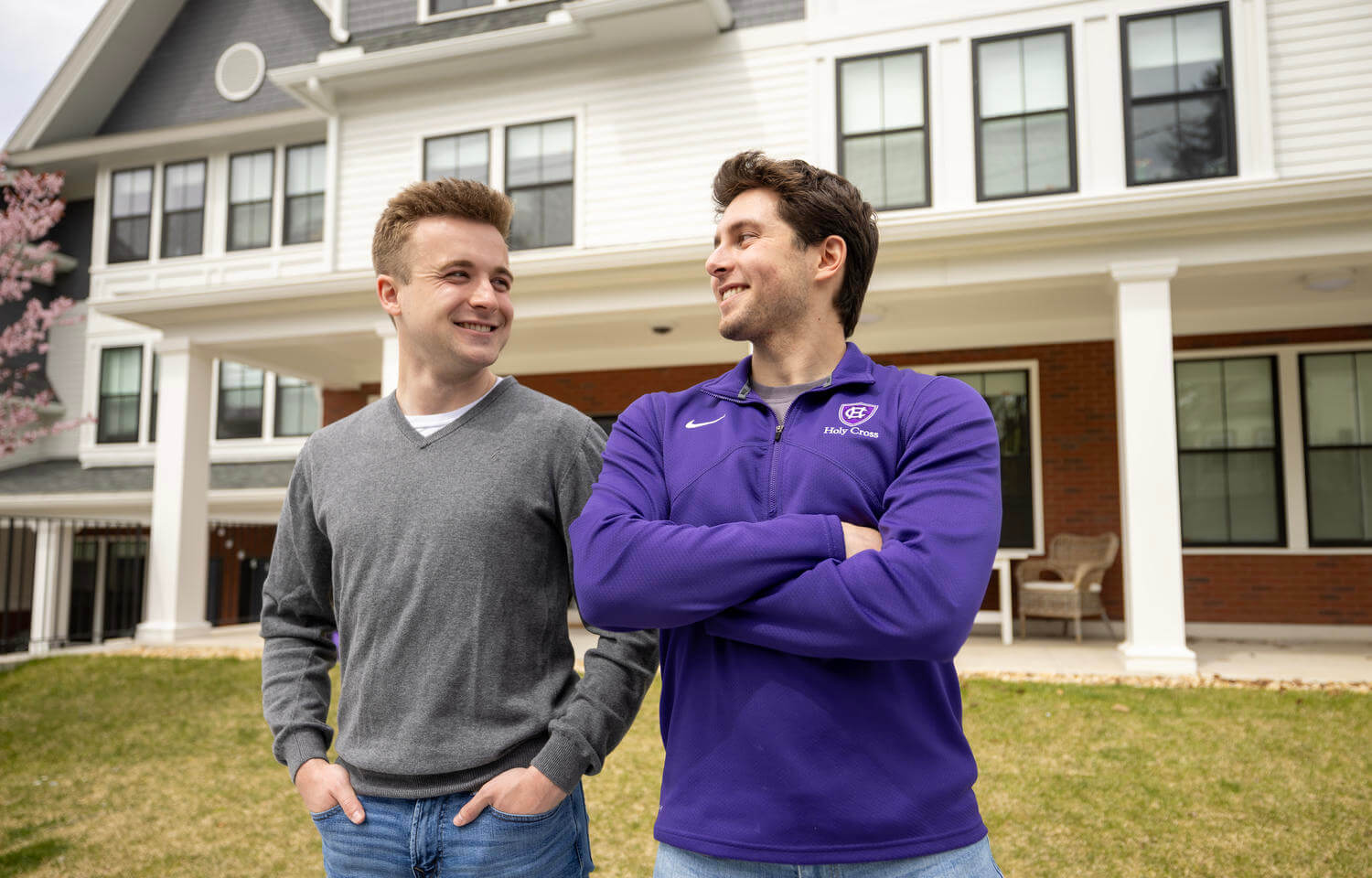 Two male college students standing outside their dorm.