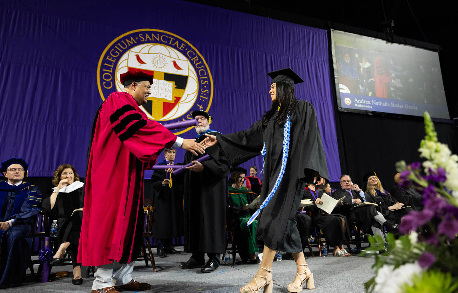 A graduate receives a degree from the college president 