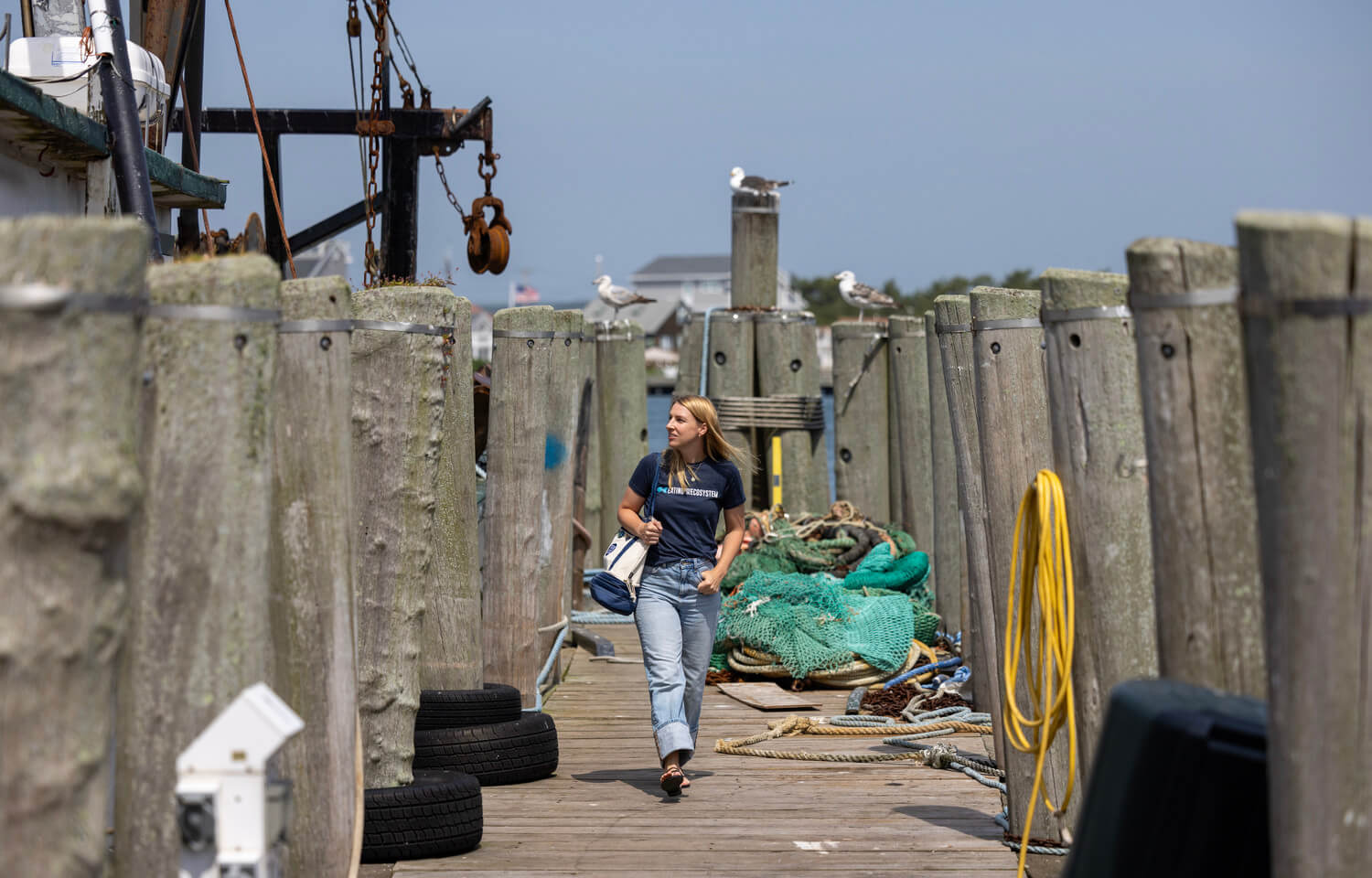 Woman walks toward camera on a dock