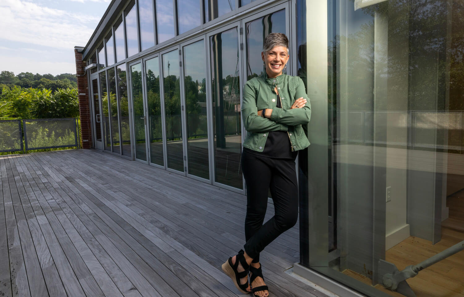 women leans against glass building