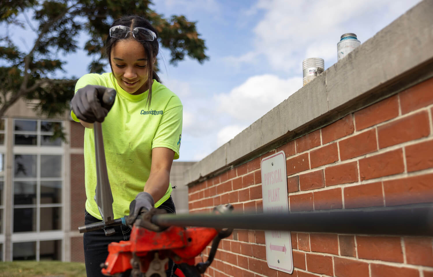 Woman plumber clamps a metal pipe