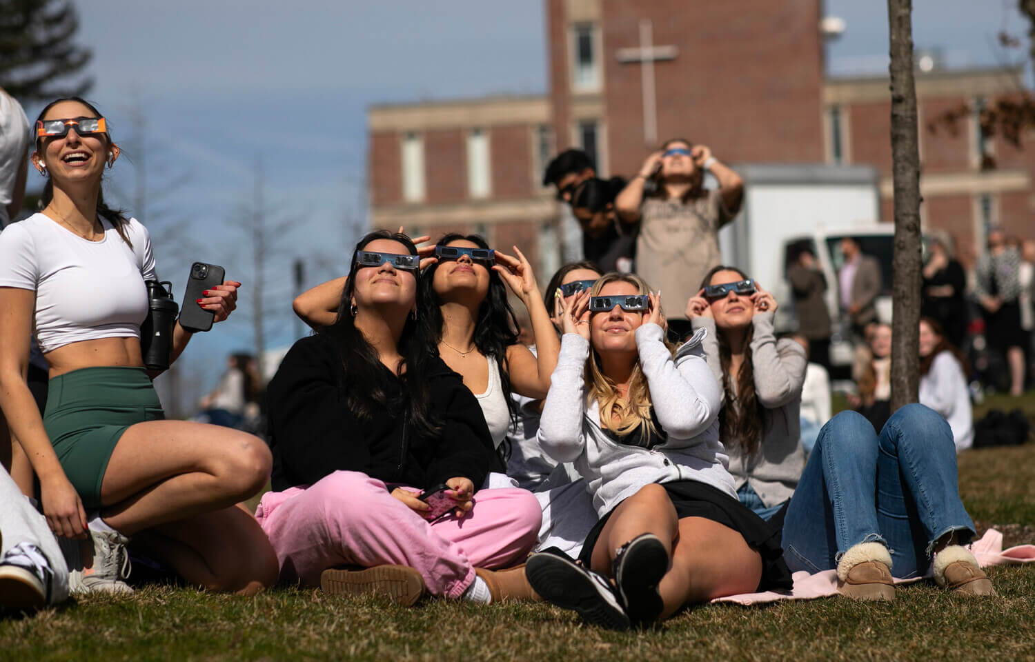 People wearing glasses stare at the sky.