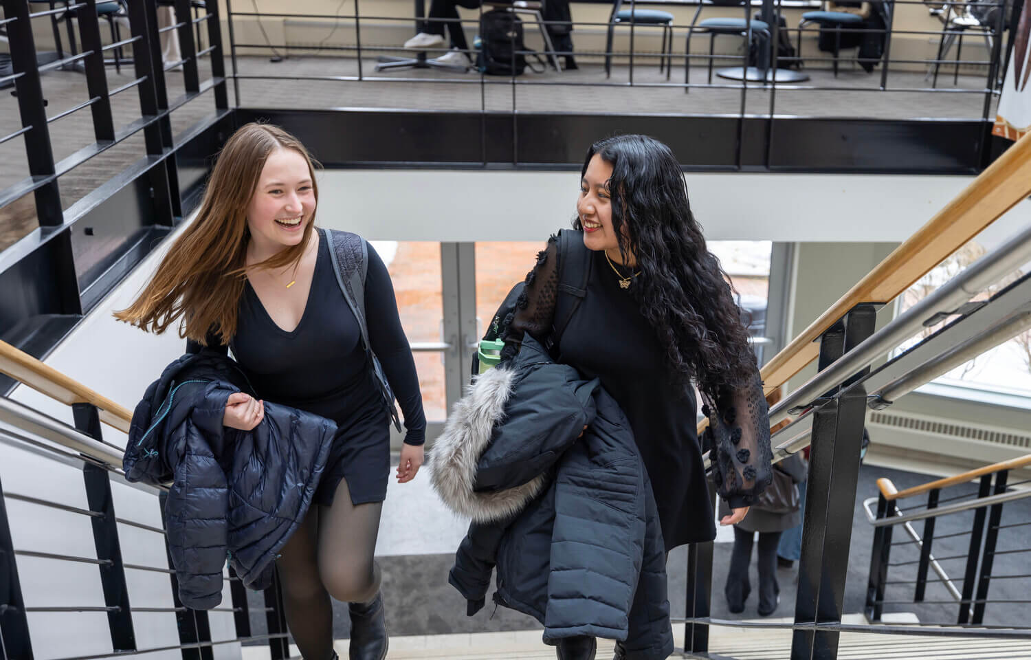 Two women walk up a flight of stairs