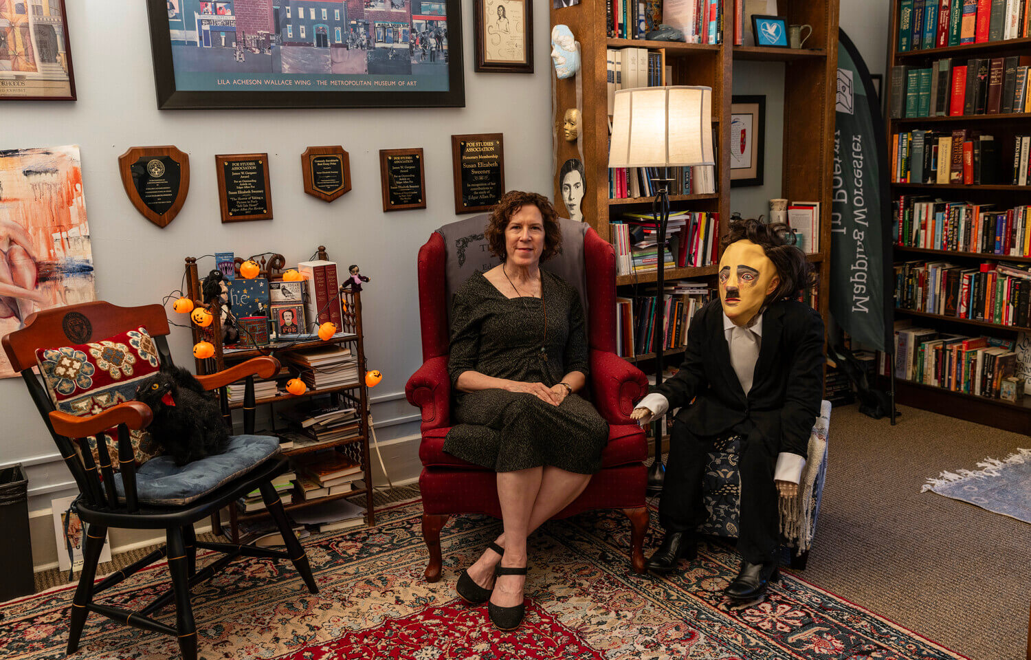 Woman, seated, with Edgar Allan Poe doll