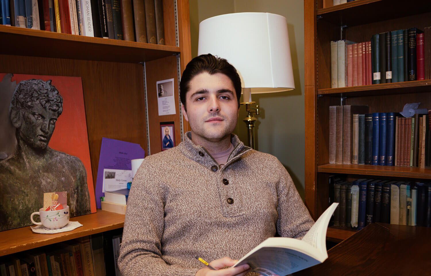 Young man with book at desk